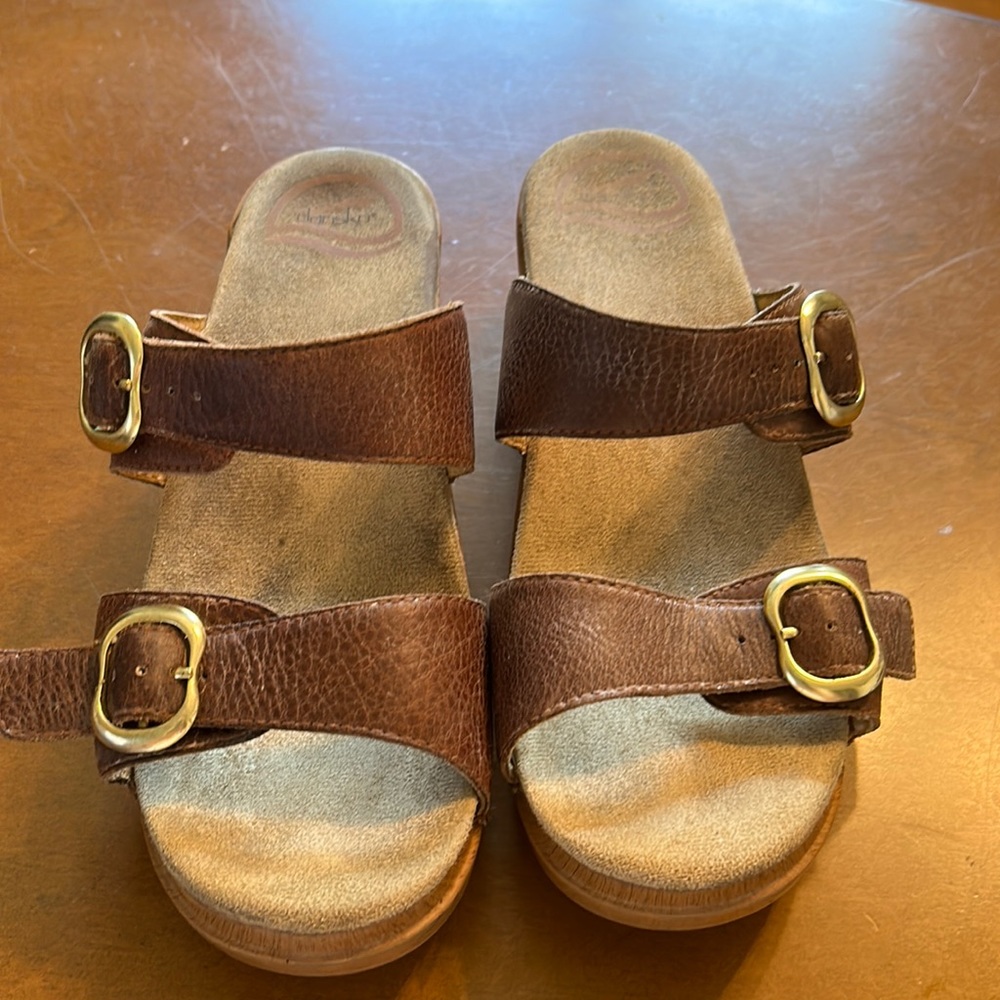 Dansko sandals.  Brown leather straps with gold colored buckles.
